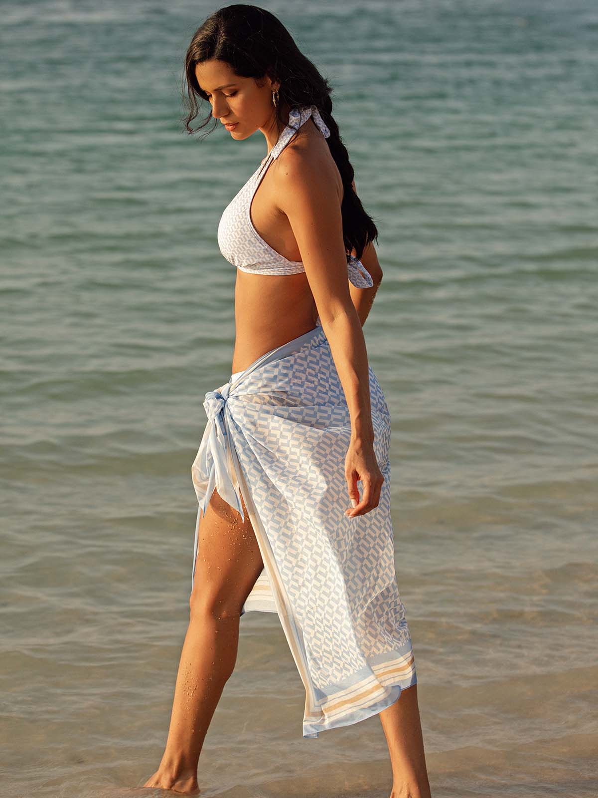 Model wearing the Elba bikini in blue geo and sarong by NAIA Beach